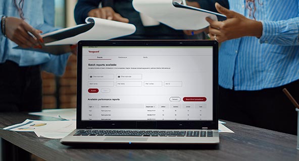 Photo of a laptop with three people in the background